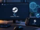 Illustration of Steam’s Loading user data screen on a desktop monitor and a handheld gaming PC.